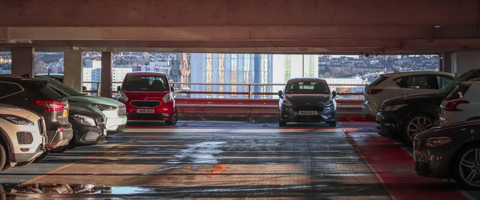 Voitures garees dans le parking collectif d un immeuble